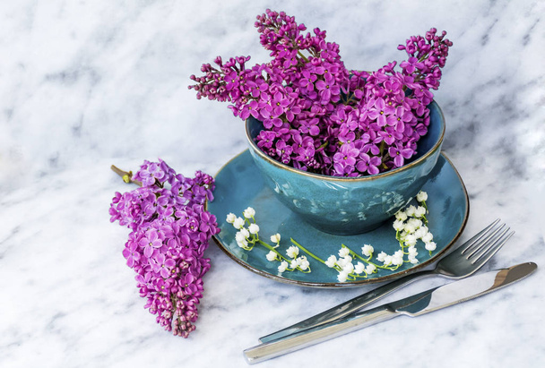 Spring Table Setting with Vintage Blue Cutlery and Lilac Flowers on a Marble  Background.Floral Table Decor  - Foto, Bild