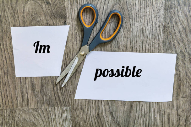 Word Impossible on Paper Cut in Two with Scissors.Positive Thinking Concept - Foto, afbeelding