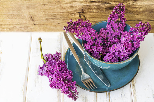 Spring Table Setting with Vintage Blue Cutlery and Lilac Flowers on a Wooden Background.Floral Table Decor  - Valokuva, kuva