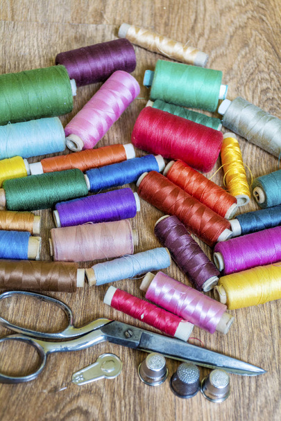 Multi Colored Thread Yarns and Vintage Scissors on Wooden Background - Fotó, kép