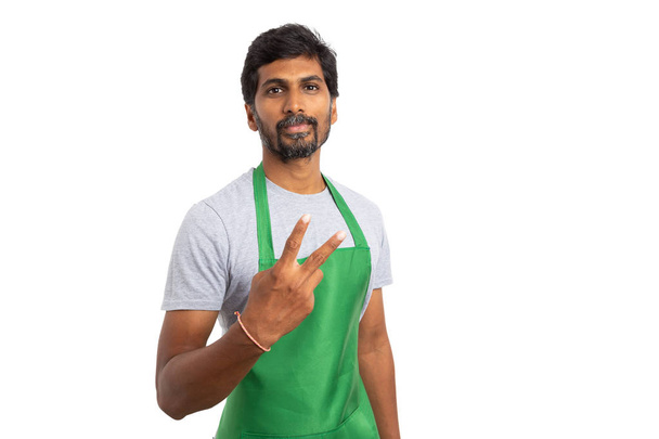 Hombre indio supermercado o hipermercado empleado sosteniendo los dedos hacia arriba y mostrando el número dos aislado sobre fondo blanco
 - Foto, imagen