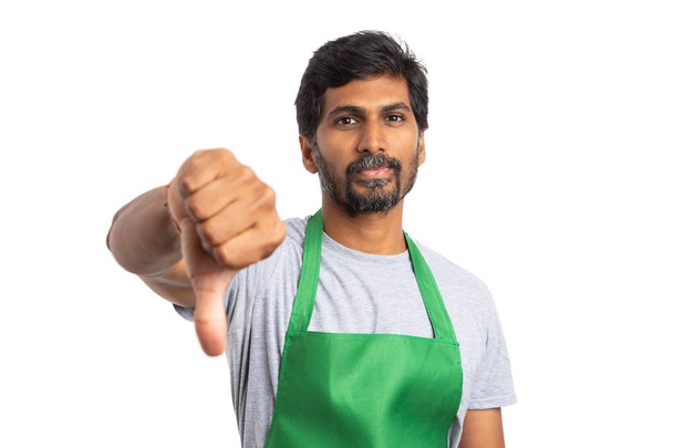 Abneigung gegen Geste mit dem Daumen nach unten von einem Supermarkt oder indischen Angestellten als Missbilligung Konzept isoliert auf weiß - Foto, Bild