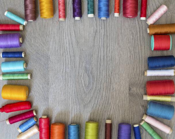 Multi Colored Thread Yarns Frame on Wooden Background - 写真・画像