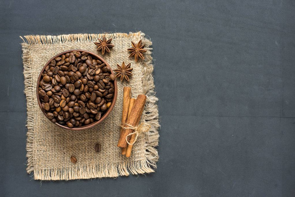Cinnamon, star anise and coffee beans in a barrel on a burlap napkin. Top view. - Foto, afbeelding