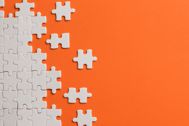 White details of puzzle on orange background. - Фото, зображення