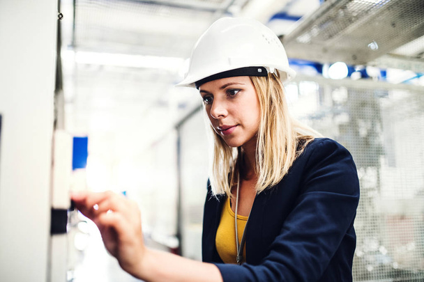 A portrait of an industrial woman engineer in a factory checking something. - Foto, Bild