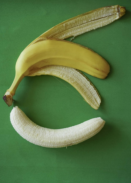 white  banana and yellow pill on green paper background - Fotografie, Obrázek