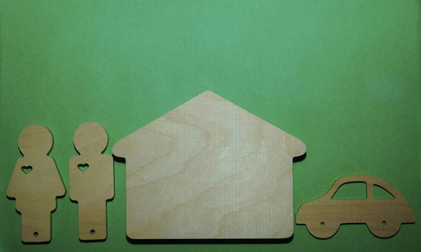 wooden figures - couple, house, car on green background - Foto, Imagen