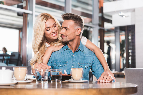 sourire belle petite amie étreignant beau petit ami pendant la date dans le café
 - Photo, image