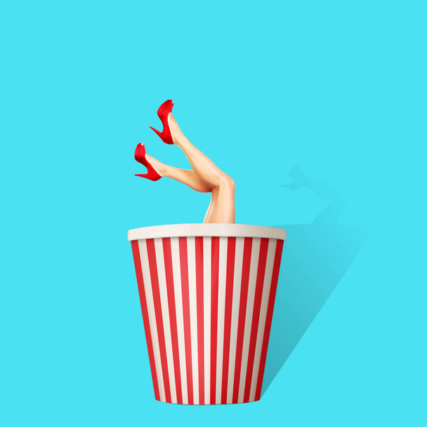 Současné umění koláž. Koncept ženské nohy vykukujících popcorn papírová krabice. Ilustrační foto. - Fotografie, Obrázek