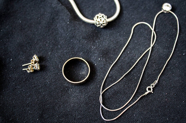 ένα δαχτυλίδι και σκουλαρίκια και βραχιόλι αλυσίδα με κρεμαστό - Φωτογραφία, εικόνα