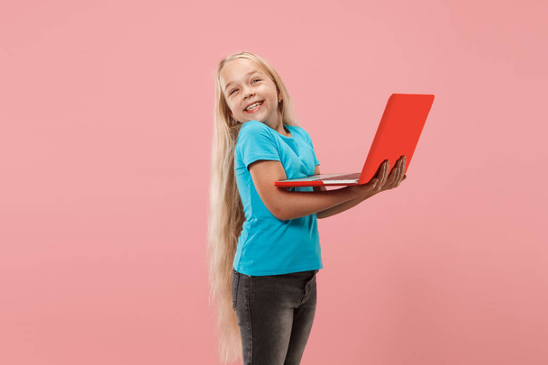 The happy child with red laptop on pink - Valokuva, kuva