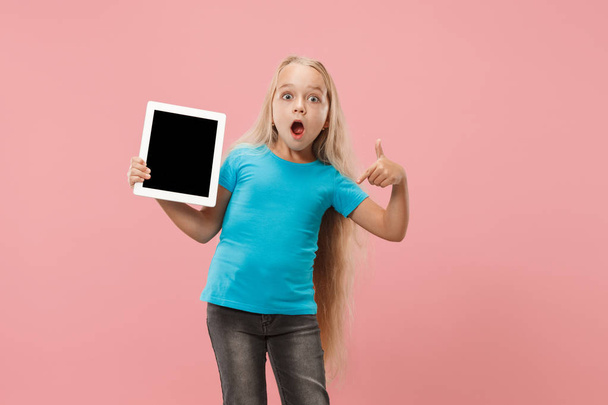 Little funny girl with tablet on pink background - Fotoğraf, Görsel