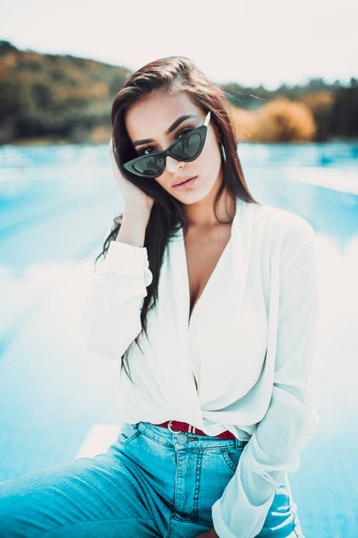 portrait of young and beautiful woman posing near swimming pool  - Zdjęcie, obraz