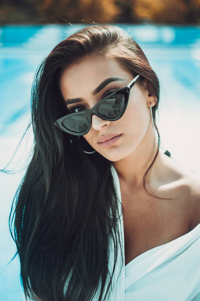 portrait of young and beautiful woman posing near swimming pool  - Фото, изображение