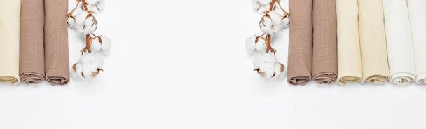 白い背景の上に綿の枝と色とりどりのきれいなタオルをコピー スペースを表示します。コットン、ワッフル タオル、繊維の質感。タオル キッチンやスパのコンセプトです。孤立オブジェクト - 写真・画像