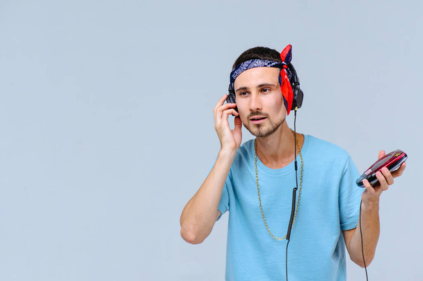 fashionable bright man in headphones in retro style manifestation of emotions of joy, gestures with hands space for text. - Fotó, kép