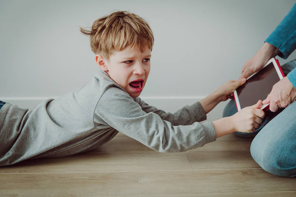 computer addiction- father taking touch pad from angry shouting child - Foto, afbeelding