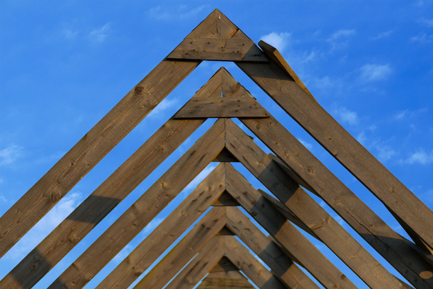 Wooden roof beams under blue skies - Foto, Imagem