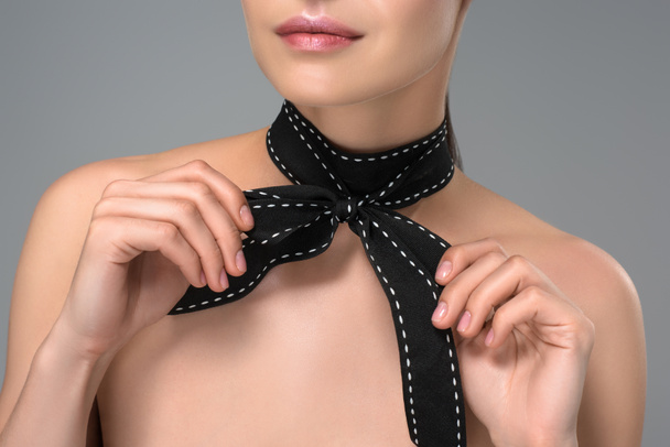 cropped shot of sensual naked girl with black bow on neck isolated on grey - Foto, afbeelding