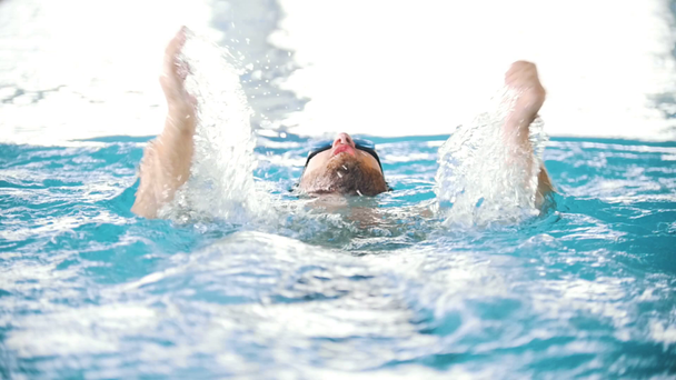 Hombre discapacitado nadando en la espalda en una piscina. El golpe de mariposa. Movimiento lento
 - Imágenes, Vídeo