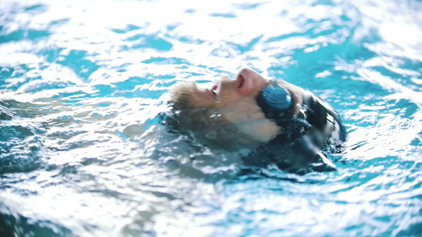 Engelli adam arkasında bir yüzme havuzunda yüzüyor. Atış kapatın. Ağır çekim - Video, Çekim