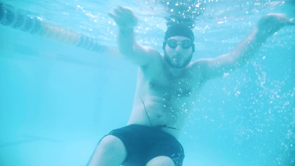 Niepełnosprawny mężczyzna pływa w basenie. Podwodne zdjęcia - Materiał filmowy, wideo