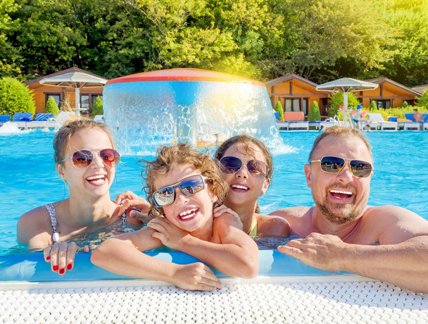 Happy family playing in swimming pool. Summer vacation concept - Valokuva, kuva
