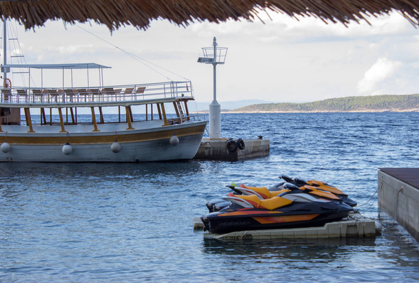 Verankerde cruise schip en water scooters in de haven van Brela in Kroatië - Foto, afbeelding
