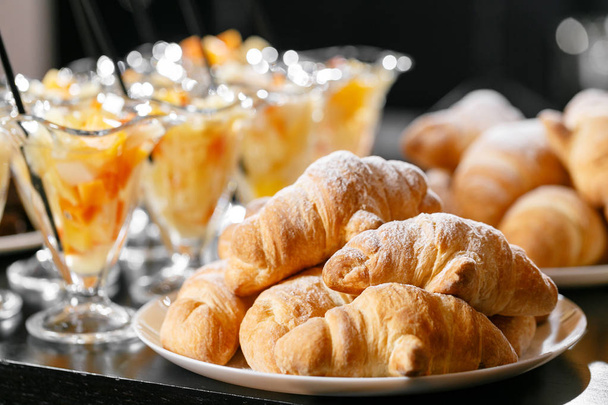 Pastelería fresca, crujientes croissants de la mañana, desayuno buffet en el hotel. Cóctel de frutas de postre en tazas
 - Foto, Imagen