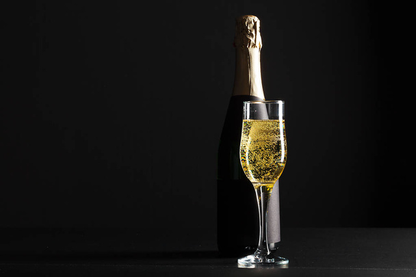 champagne wine glass and bottle on black background - Фото, изображение