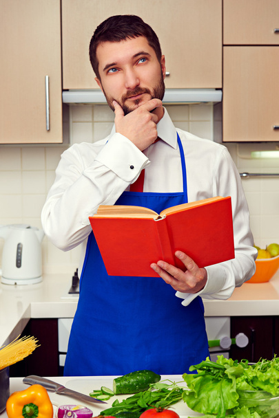 jeune cuisinier avec livre de cuisine penser à la recette
 - Photo, image