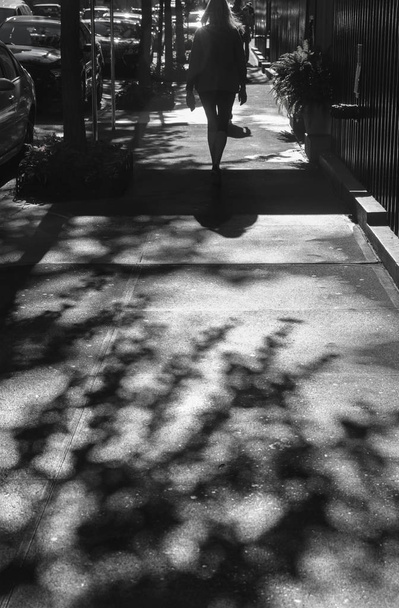 Licht en schaduwen in New York City. Schaduwen van mensen lopen straat in ochtend licht - Foto, afbeelding