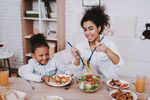 Mom and Daughter Time Together. Mother Pours Food Girl. Creativity Time for Little Girl. ChildHood for Mother. Happy Girl Eat Food with Mother. Mulatto and Young Girl Eat Food. Happy Day with Family. - Foto, imagen