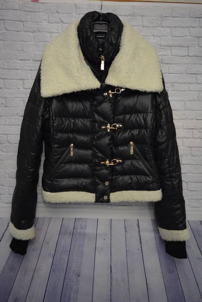 Black stylish women's down winter jacket with white fur, a substitute with a gold forniture - Photo, Image