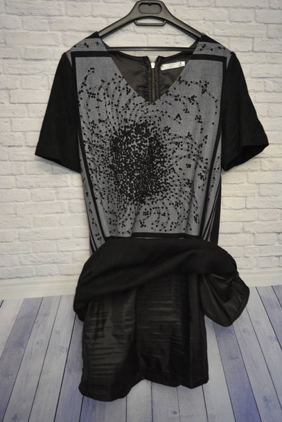 Herbstkleid der Frauen Wolle schwarz mit grauem Print mit Reißverschluss an der Wand ihrer weißen Bauklötze - Foto, Bild