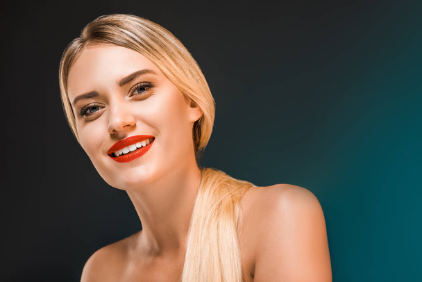 portrait of beautiful smiling woman with red lips on dark background - Foto, Imagem