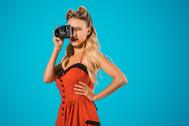 beautiful woman in retro dress with photo camera isolated on blue - Foto, afbeelding