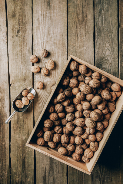 top view of tasty healthy walnuts in box on wooden table - Photo, image
