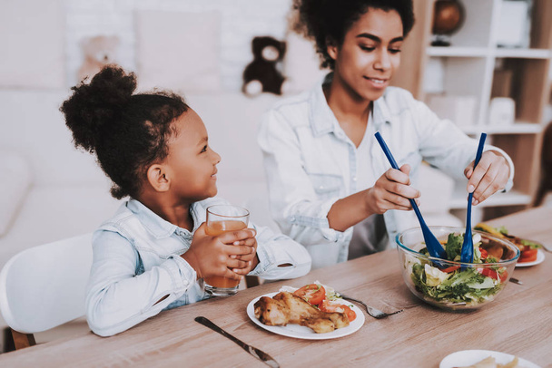 Young Girl with Mother Time Together. Love Mom and Beautiful Girl. Mulatto Mother and Mulatto Girl Time Together. People Relaxation and Eat Food. Smile Little Girl and Young Mother. Beautiful Girl. - Fotoğraf, Görsel