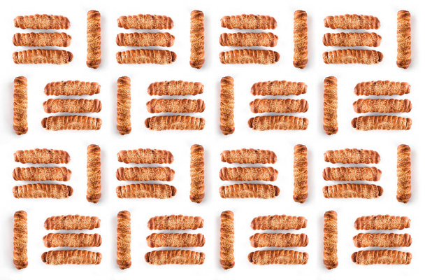 Conceito de alimento a partir de conjuntos de salsichas na massa com sementes de gergelim isoladas em fundo branco
 - Foto, Imagem