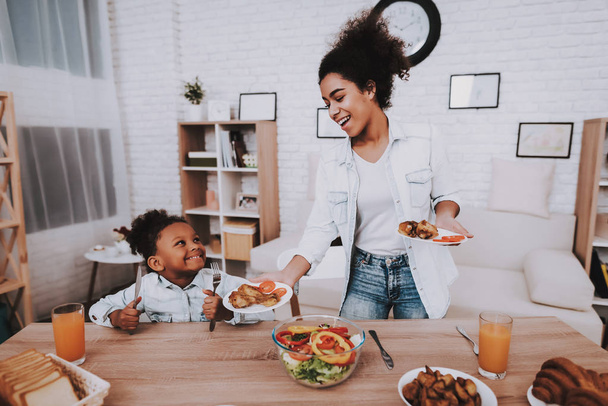 Mother and Girl Dring Juice Happy Moment Together. Mulatto and Mother Time Together. Love Mother and Daughter. People Eat Together. Mother give Little GIrl Chicken. Happy Gilr and Beautiful Mother. - Zdjęcie, obraz