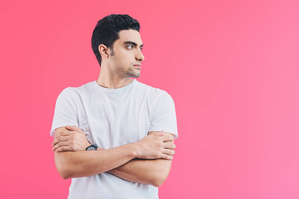 handsome man standing with crossed arms and looking away isolated on pink - Photo, Image