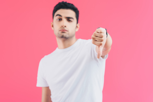 grimacing handsome man showing thumb down isolated on pink - Photo, Image