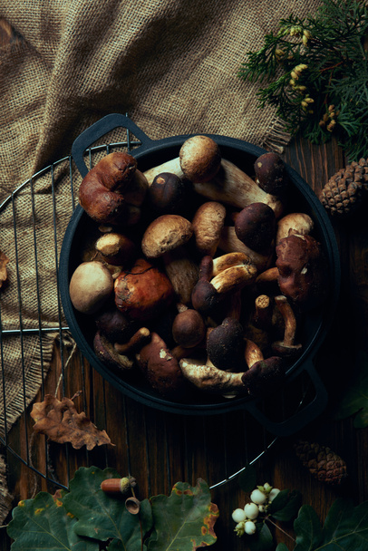top view of fresh picked mushrooms in pan on wooden table  - 写真・画像