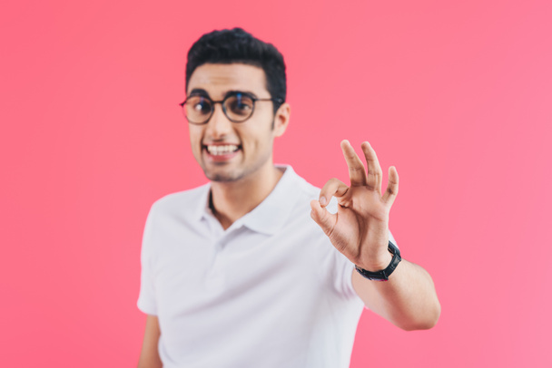 selective focus of smiling handsome man showing isolated on pink - Foto, Imagen