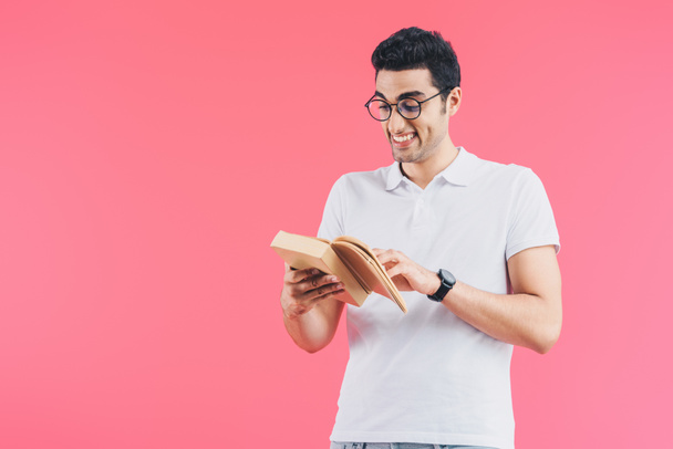 grimacing smiling student reading book isolated on pink - Foto, Imagem