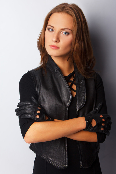 Beautiful young woman wearing leather vest - Фото, зображення