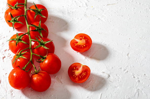 Hermosos tomates cherry en rama. Sobre fondo blanco texturizado
. - Foto, imagen