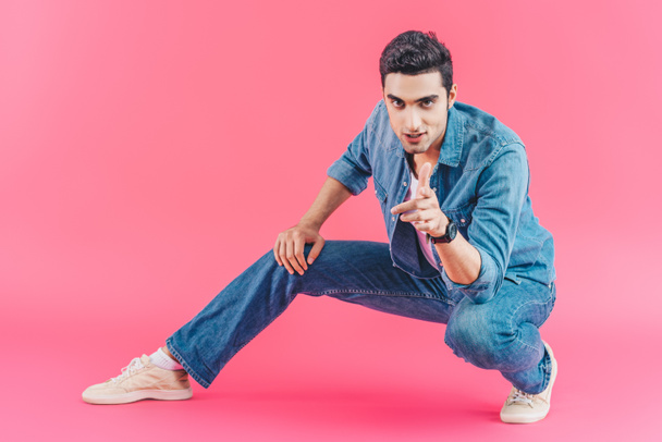 stylish man pointing at camera on pink background - Foto, imagen